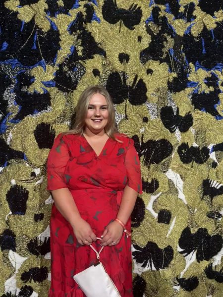 Ellie Scott infront of the Golden Threads tapestry bu Kustaa Saksi